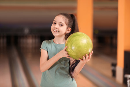 Little girl with ball in bowling clubの写真素材