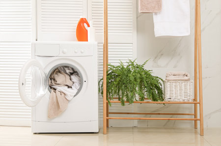 Modern washing machine with towels in the bathroomの写真素材