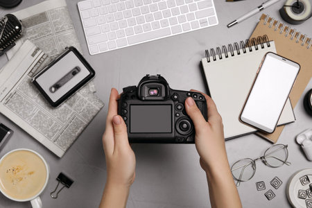Journalist with camera at gray table, top viewの写真素材