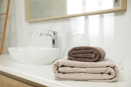 Stack of clean towels on bathroom countertop. Space for textの写真素材