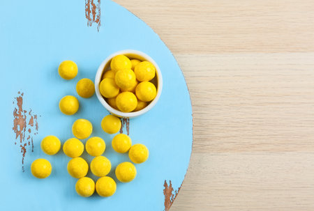 Tasty lemon drops on wooden table, flat lay. Space for textの写真素材
