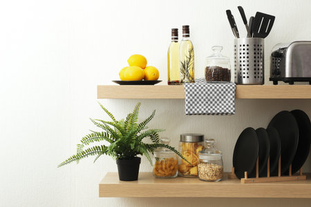 Wooden shelves with dishware and products on white wall. kitchen interior ideasの写真素材