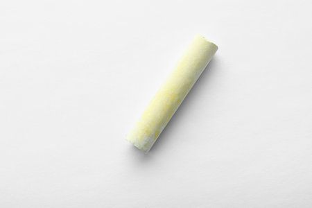 Small piece of yellow chalk isolated on white, top viewの写真素材