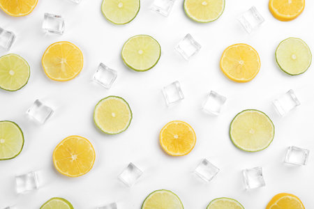 Lemonade layout with ice cubes, lime and orange slices on white background, top viewの写真素材