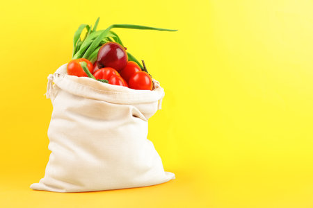 Cotton eco bag with vegetables on yellow background. Space for textの写真素材