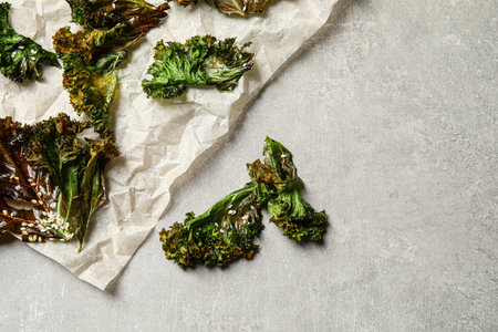 Tasty baked kale chips on gray table, flat layの写真素材