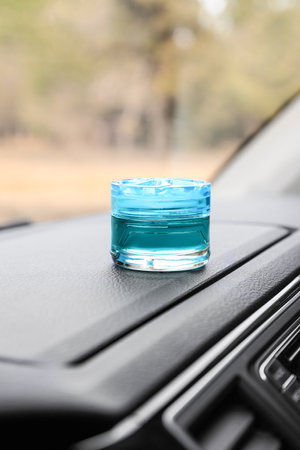 Stylish air freshener on dashboard in car