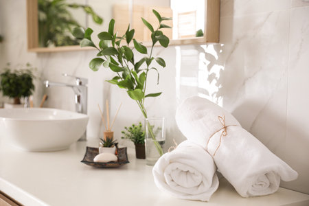 Towels and green plants on white countertop in bathroom. interior designの写真素材
