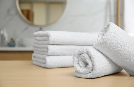White fresh towels on wooden table in bathroom, closeupの写真素材