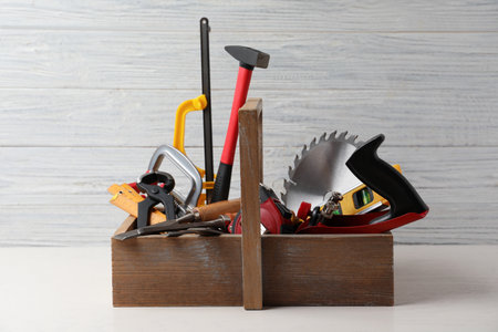 Box with carpenter's tools on white table