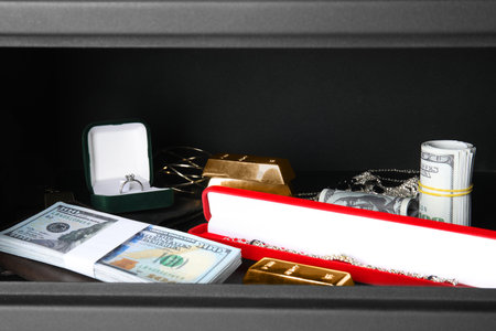 Open steel safe with money and jewelryの写真素材