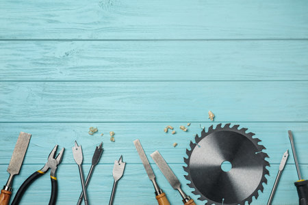 Flat lay composition with carpenter's tools on light blue wooden background. Space for text