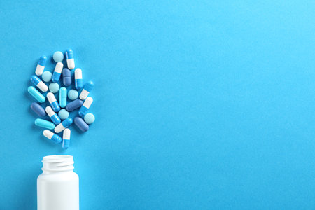 Flat lay composition with pills on light blue background. Space for textの写真素材