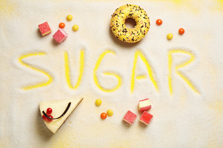 Flat lay composition with sweets and word SUGAR on yellow backgroundの写真素材