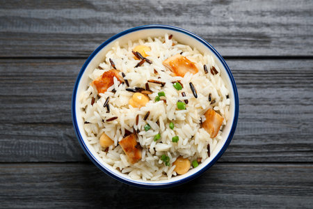 Delicious rice pilaf with chicken on black wooden table, top viewの写真素材