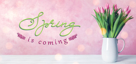 Beautiful tulips in vase on white table. hello spring