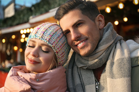 Happy couple in warm clothes at winter fair. christmas seasonの写真素材