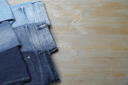 New stylish jeans on wooden background, flat lay. Space for textの写真素材