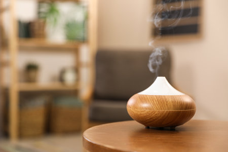 Aroma oil diffuser on wooden table at home, space for text. air freshenerの写真素材