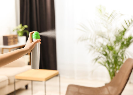 Woman spraying air freshener at home, closeupの写真素材