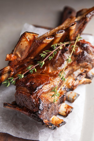 Delicious roasted ribs served on table, closeup