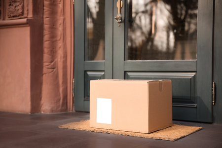 Delivered parcel on door mat near entrance