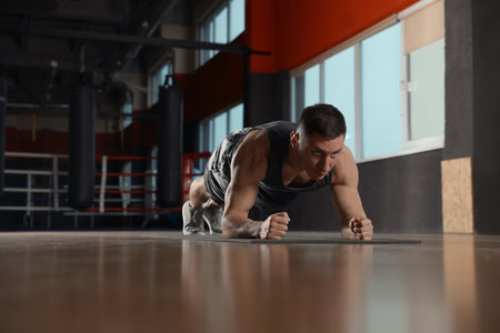 Man doing plank exercise in modern gymの写真素材