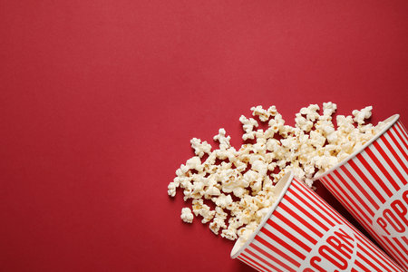 Flat lay composition with delicious popcorn on red background. Space for textの写真素材