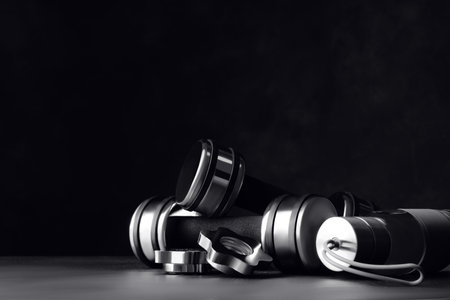 Gym equipment and accessories on floor against dark background. Space for textの写真素材