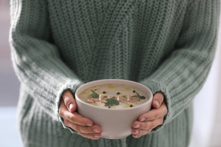 Young woman with bowl of cream soup, closeupの写真素材