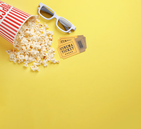 Flat lay composition with delicious popcorn on yellow background. Space for textの写真素材