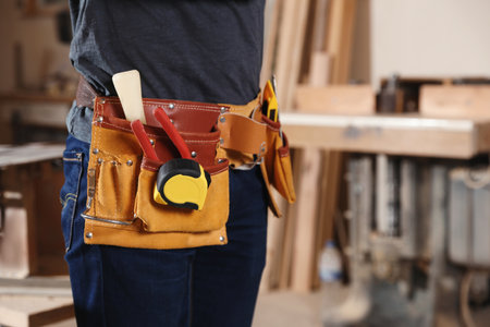 Professional carpenter with tools in workshop, closeup. Space for textの写真素材