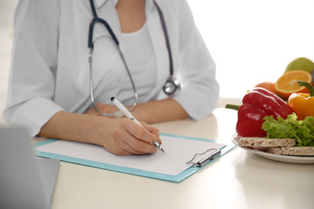 Nutritionist working at desk in office, closeupの写真素材