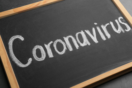 Chalkboard with word CORONAVIRUS on gray table, closeupの写真素材