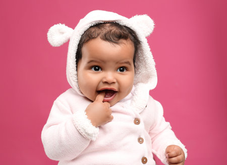 Cute African American baby on pink background
