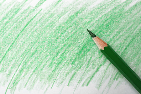 Green pencil on sheet of paper with drawing, top viewの写真素材