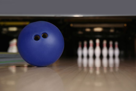 Blue ball on bowling lane in club. Space for textの写真素材