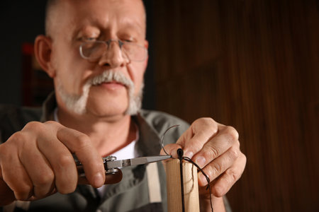 Man sewing piece of leather in workshop, closeupの写真素材