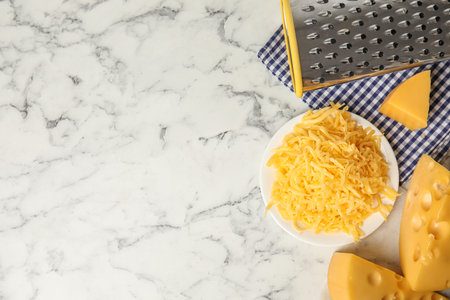 Flat lay composition with grated cheese on white marble table. Space for textの写真素材