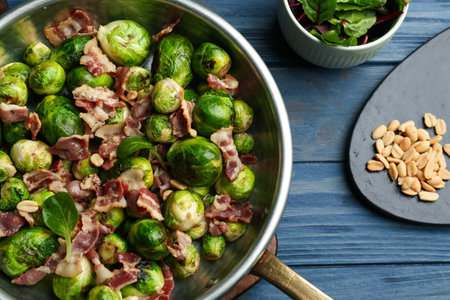 Delicious Brussels sprouts with bacon on blue wooden table, flat layの写真素材