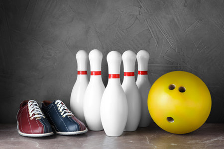 Bowling shoes, pins and ball on gray marble tableの写真素材
