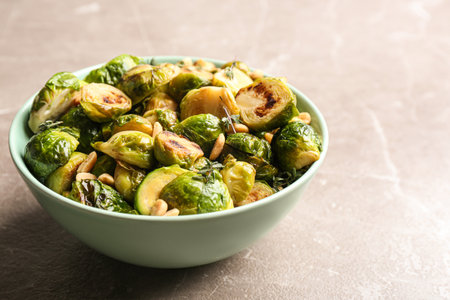 Delicious roasted brussels sprouts with peanuts on gray marble table, closeupの写真素材