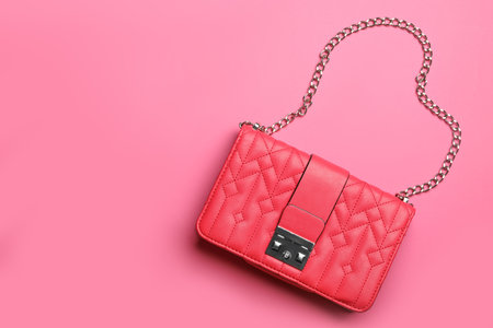 Stylish small woman's bag on pink background, top view. Space for textの写真素材