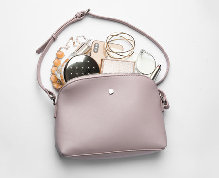 Stylish woman's bag with smartphone and accessories on white background, top viewの写真素材