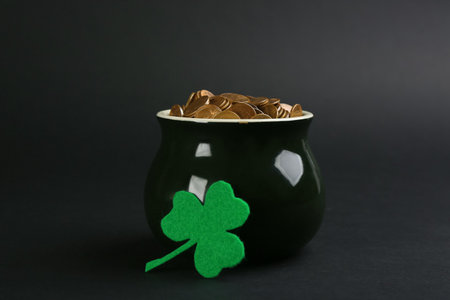 Pot of gold coins and clover on black background. St. Patrick's Day celebrationの写真素材