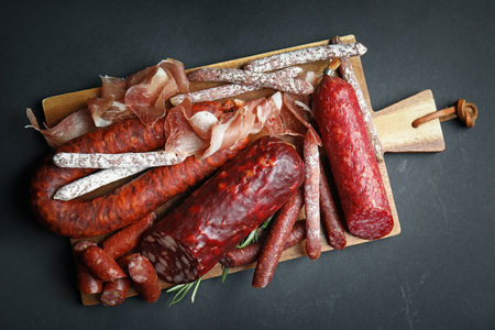 Different types of sausages served on black background, top viewの写真素材