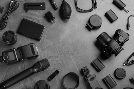 Frame made with camera and video production equipment on gray stone background, flat lay. Space for textの写真素材