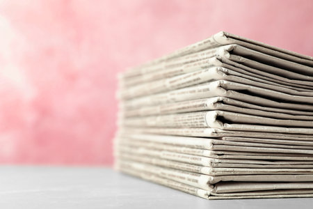 Stack of newspapers on pink background, closeup. Journalist's workの写真素材