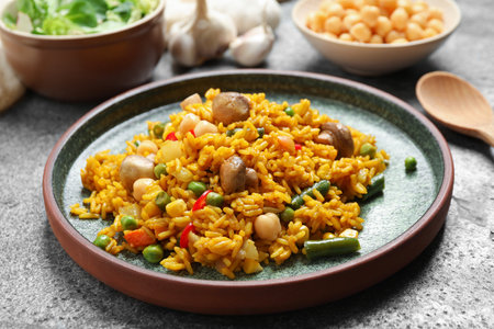 Delicious rice pilaf with vegetables on gray tableの写真素材