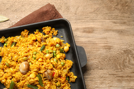 Delicious rice pilaf with vegetables on wooden table, top viewの写真素材